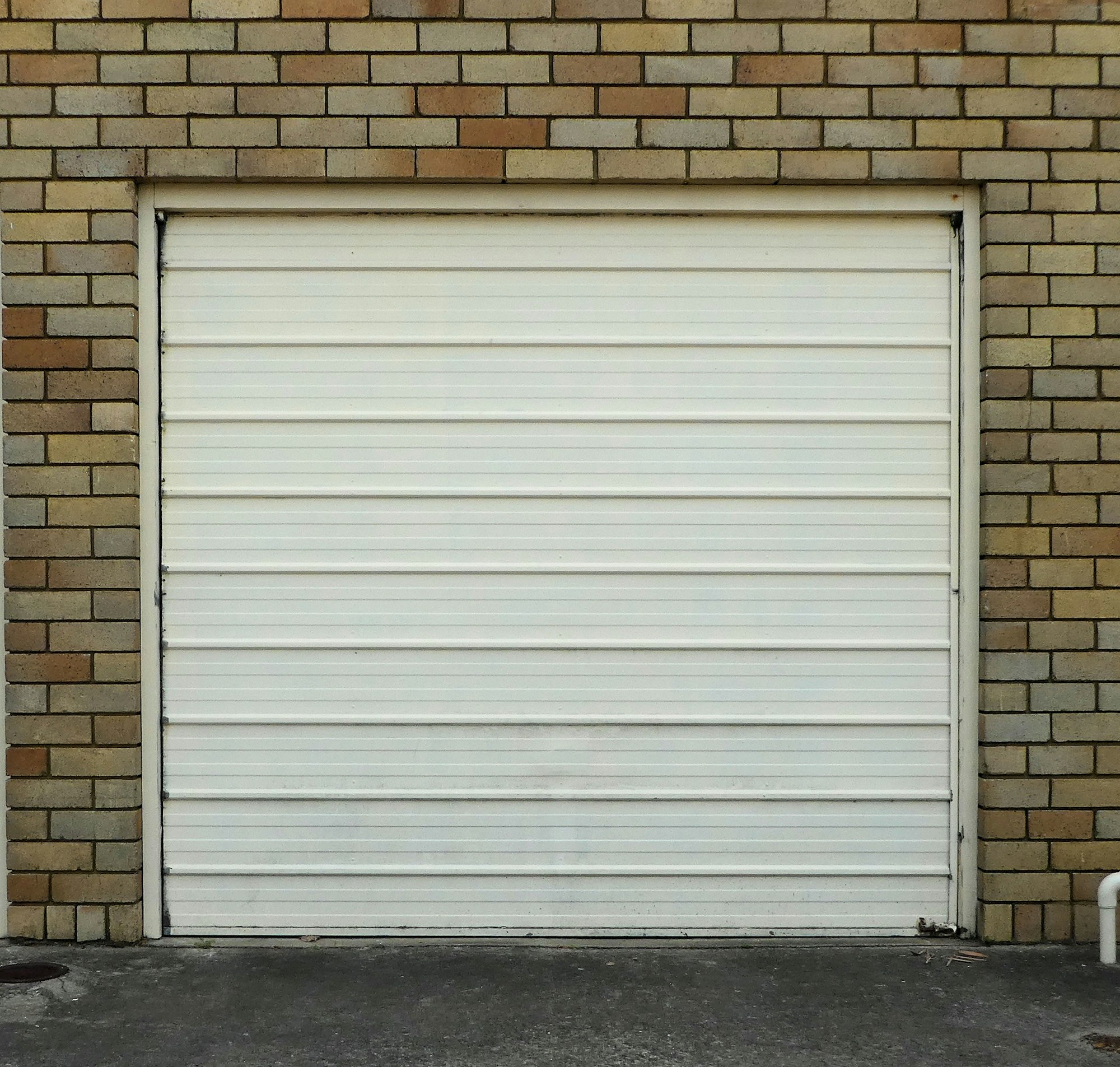 Garage door,cream colour against blonde brick frame